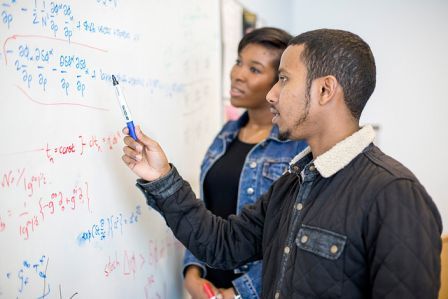 Two Maths students at a whiteboard