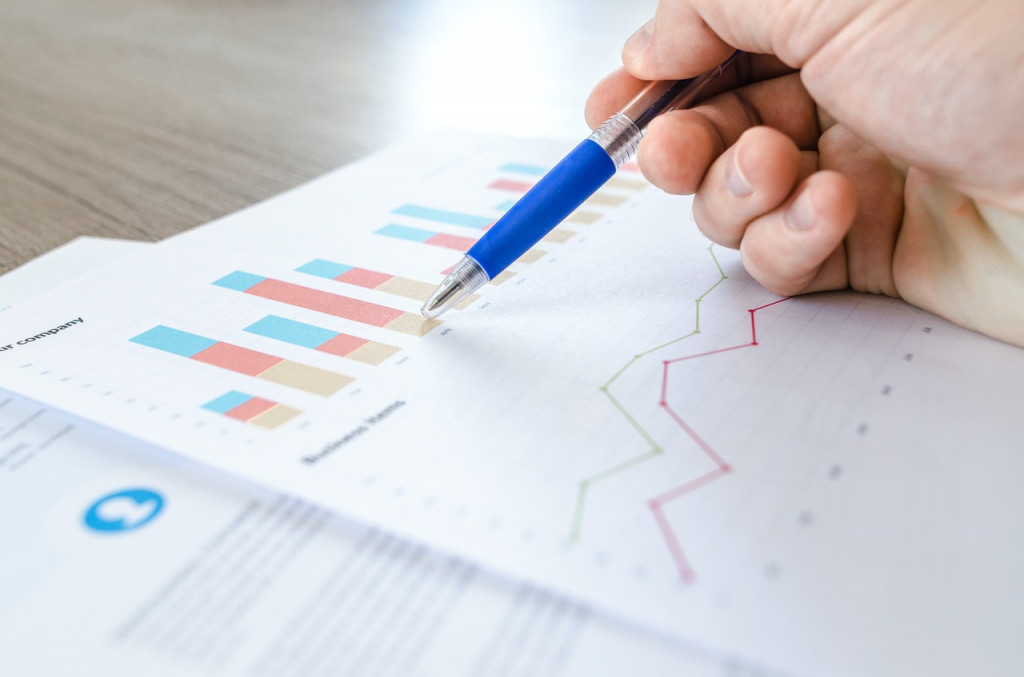 Student or business person working with printed charts and spreadsheets
